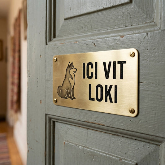 Plaque « Ici vit Loki » en laiton gravé, silhouette de chien, vissée sur une porte